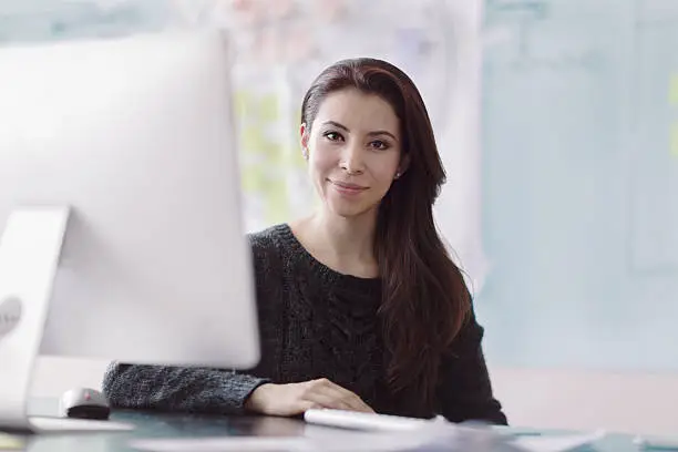 Portrait of woman next to computer in studio office