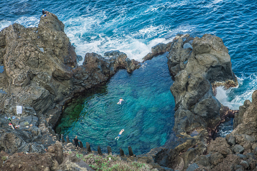 People swimming in natural swimming pool Charco De La Laja, at the north of Tenerife, Canary Islands, Spain