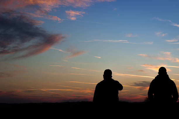 istock Silhouette of two man hiking 637933274