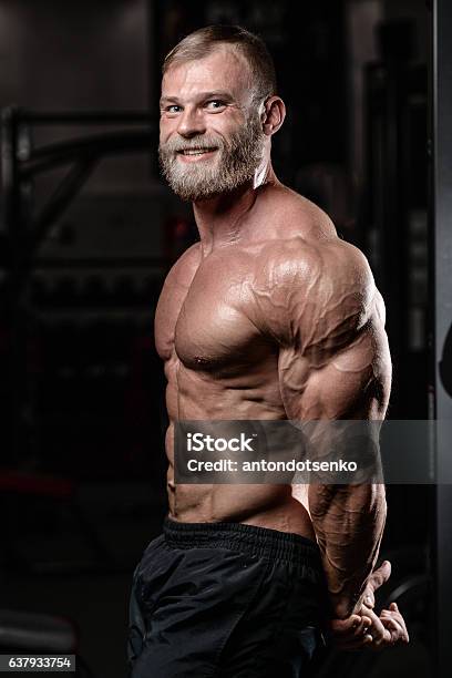 Foto de Brutal, muscular, bald with a beard athlete in the gym
