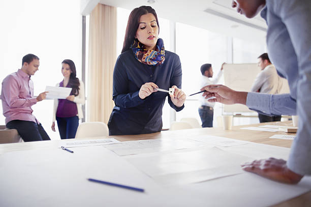 istock Woman discussing part design with colleague in innovation studio 637934624