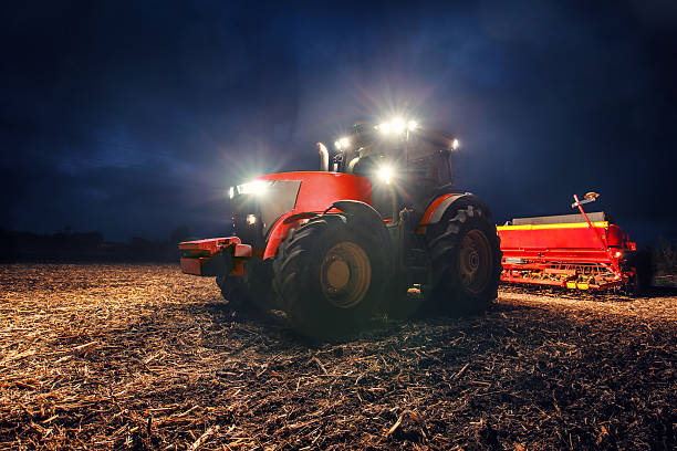 istock Tractor preparing land with seedbed cultivator at night 637938348