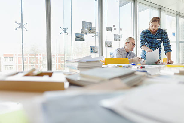 two men talking about ideas in office planning studio - book school desk old imagens e fotografias de stock