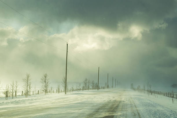 istock Road in winter with ground drifting during a snow squall 637943018
