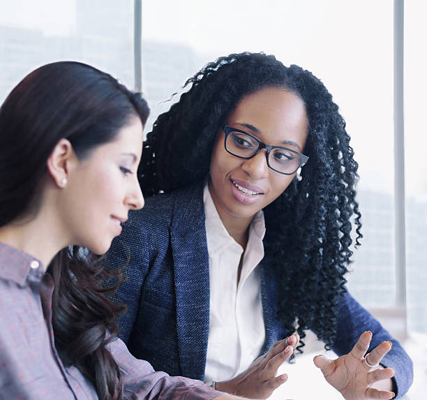 Women having conversation together in business office Women having conversation together in business office women satisfaction decisions cheerful stock pictures, royalty-free photos & images