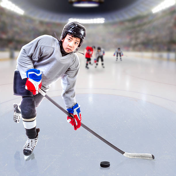 istock Junior Ice Hockey Player in Crowded Arena 637944916