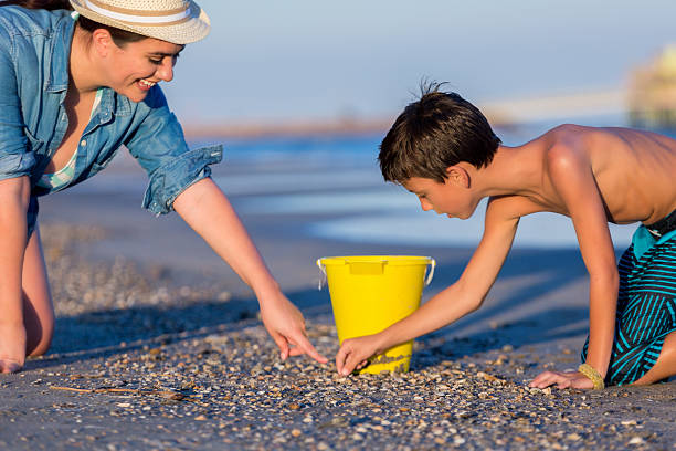 baby on the beach playing with bucket and water