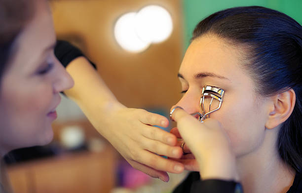 makeup artist applying eyelash curler - close to moving up closed women imagens e fotografias de stock