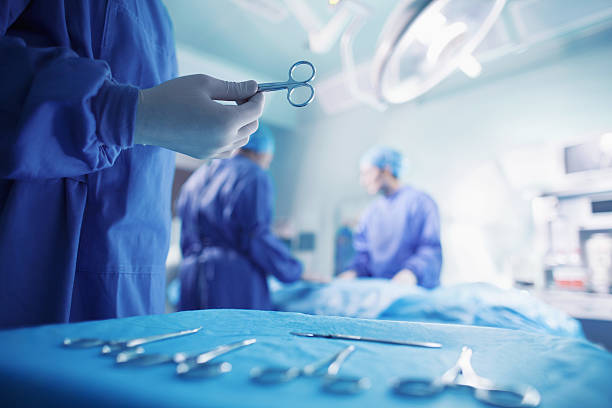 врачи выполнении хирургического вмешательства в больнице операционная - surgery стоковые фото и изображения