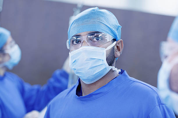 médico mirando hacia arriba para monitorear en el quirófano del hospital - hair net nurse scrubs asian ethnicity fotografías e imágenes de stock