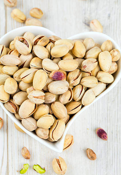 istock heart-shaped bowl full of pistachio nuts 637949976