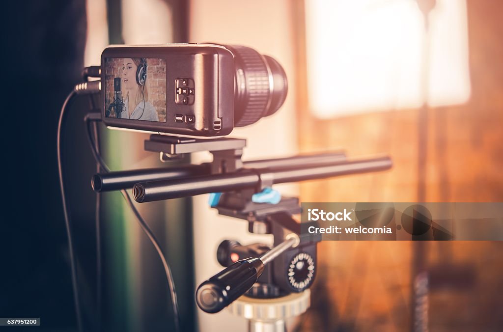 Video Equipment in Action Modern Compact Video Equipment in Action. Small Video Camera on Tripod. Girl Singing to Microphone on the Camera Display. Adult Stock Photo