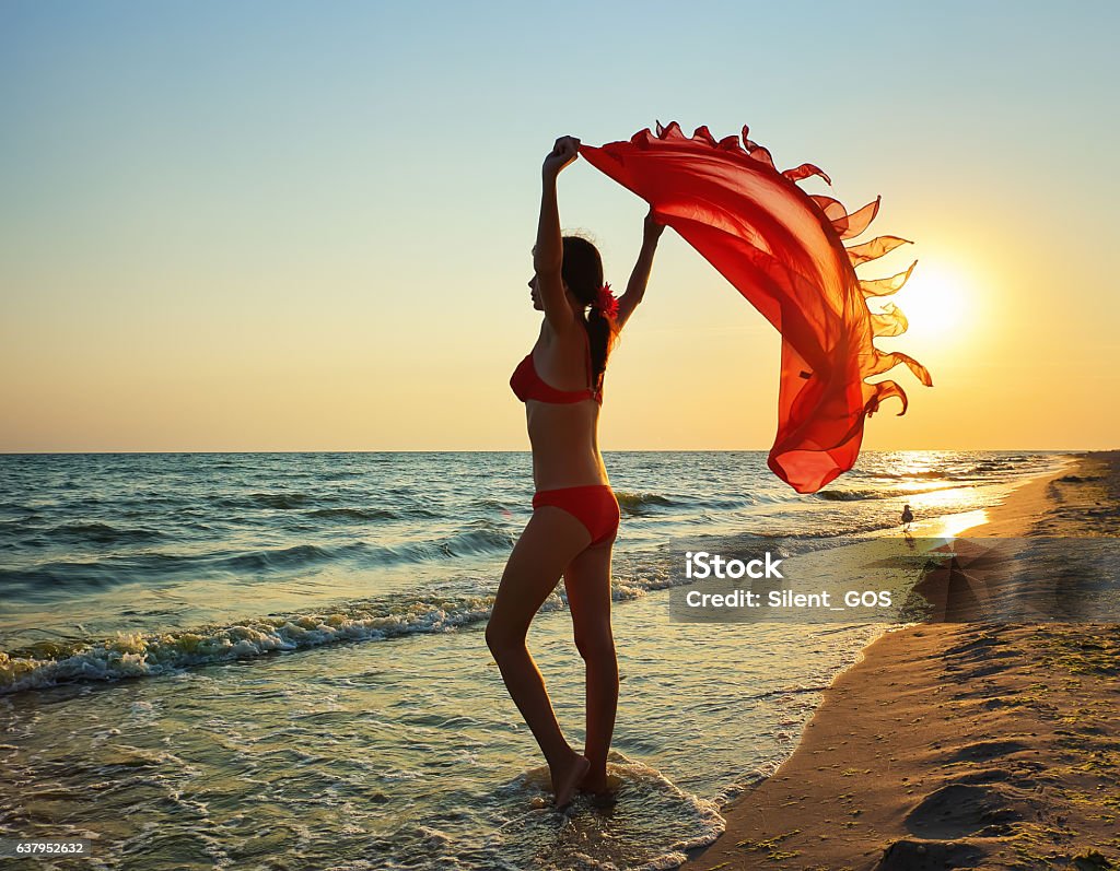 slender beautiful woman girl on beach with pareo shawl. Adult Stock Photo