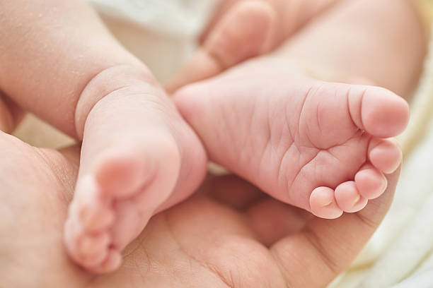 istock Newborn baby feet in dad's hand 637953378
