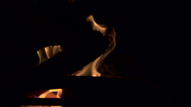 Stoking a wood burning stove with flying red hot embers making this a beautiful shot
