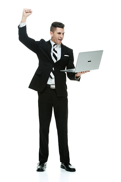 istock Smiling businessman cheering with laptop 637954400