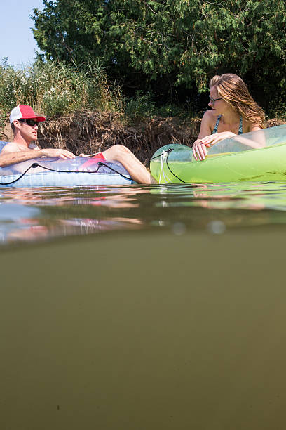 istock Couple tubing down the river in the summer 637957798