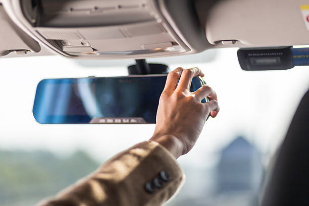 istock man's hand holds rear view mirror of car 637963036