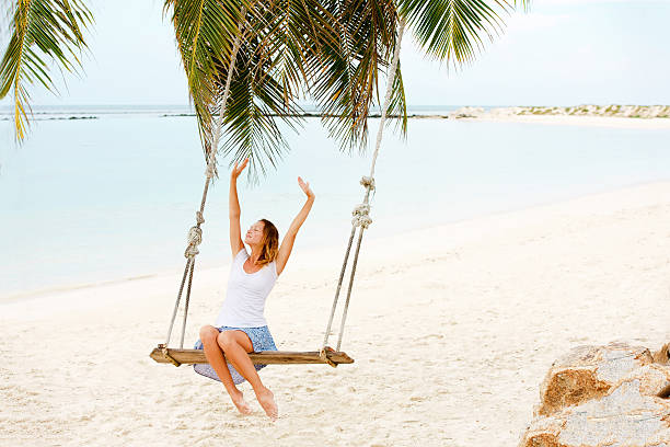 istock Beautiful Woman Swinging on Beach 637968254