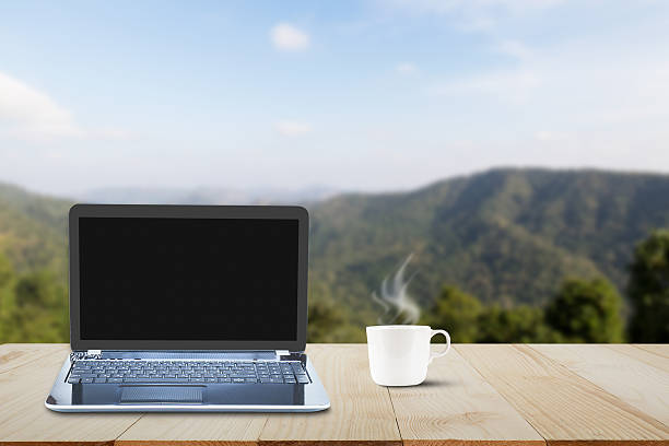 istock Computer laptop  and hot coffee cup on wooden table 637968380