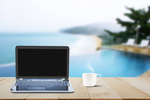 istock Computer laptop and hot coffee cup on wooden table 637968406