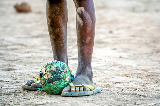 Poor african boy football stock photo