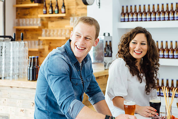 istock Man and woman smiling at table with beer 637974822