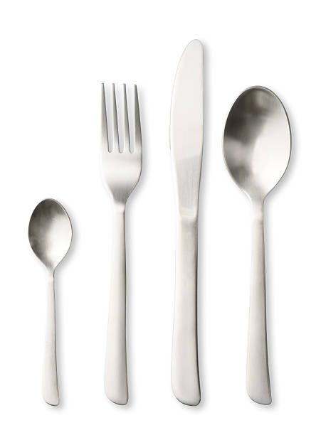 столовый нож, ложка, чайная ложка и вилка на белом фоне - eating utensil silverware four objects small group of objects стоковые фото и изображения