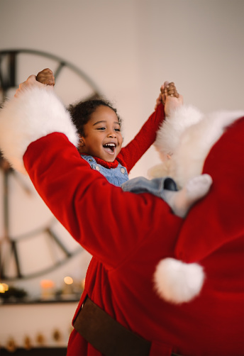 Santa Claus playing with cute African american Child at Home near Christmas tree