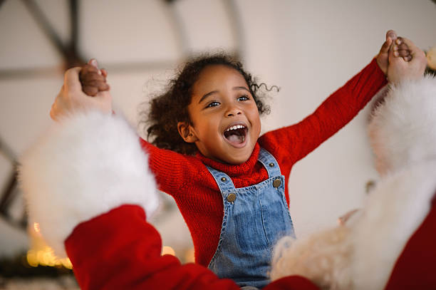 Santa Claus playing with Child Santa Claus playing with cute African American Child at Home magic trick photos stock pictures, royalty-free photos & images