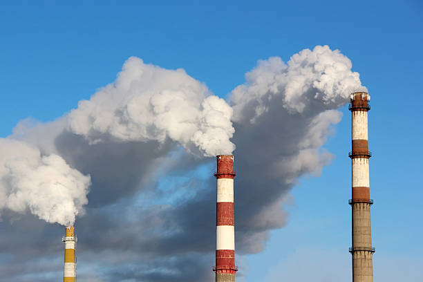 istock Dense smoke burst from the three factory chimneys. 637977198
