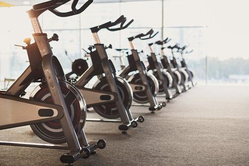 Moderno interior del gimnasio con equipamiento, bicicletas estáticas de fitness photo