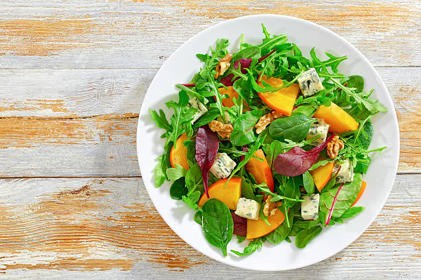 istock healthy delicious salad with persimmon slices, top view 637979772