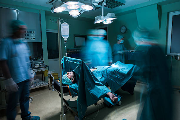 istock Male patient on operating table among blurred surgeons. 637980876