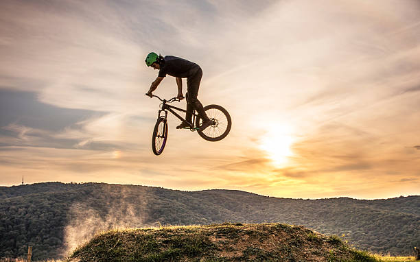 homem habilidoso na mountain bike praticando 360 xup ao pôr do sol. - bmx cycling - fotografias e filmes do acervo