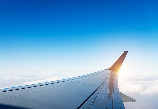 Airplane wing in flight above clouds Airplane wing in flight above clouds. aircraft wing stock pictures, royalty-free photos & images