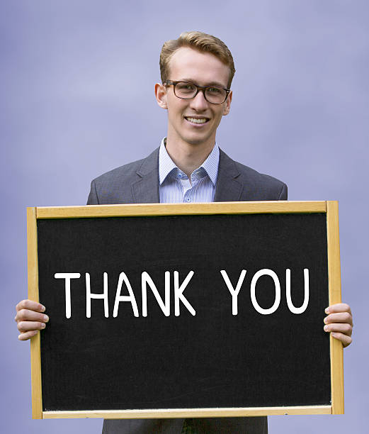 istock young man holding chalkboard with words Thank You 637985392