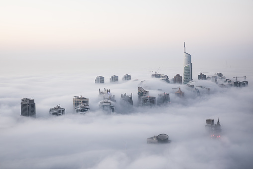 Rare winter morning fog blanketing Dubai skyscrapers in the Marina district.