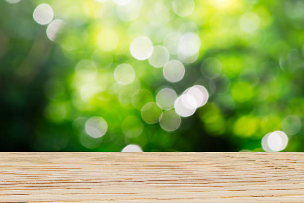 istock Wooden table top on blurred nature green bokeh background 637990800