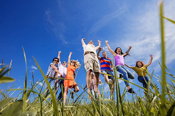 istock Below view of happy people jumping in a meadow. 637991740