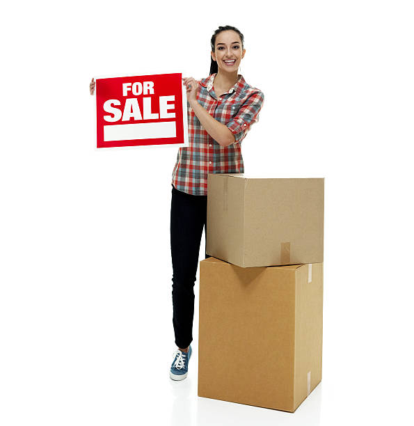 istock Smiling female holding for sale sign 637991744
