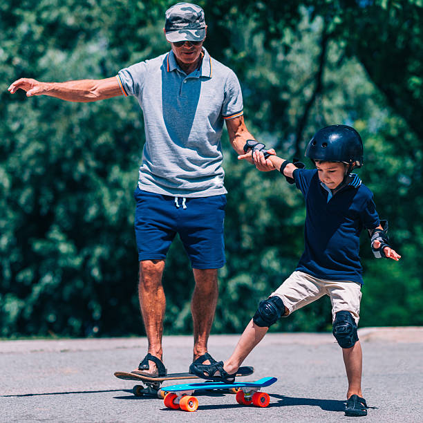 istock Grandfather and grandson trying skateboards 637991934