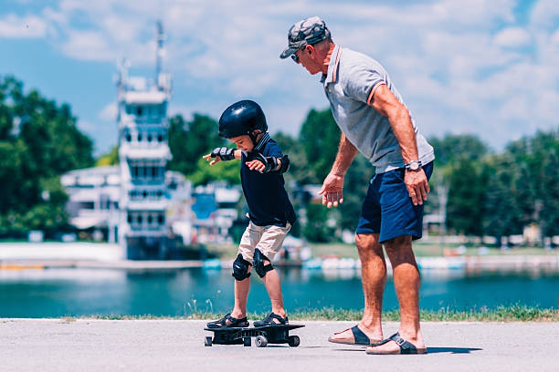 istock Grandfather and grandson trying a snakeboard 637992306