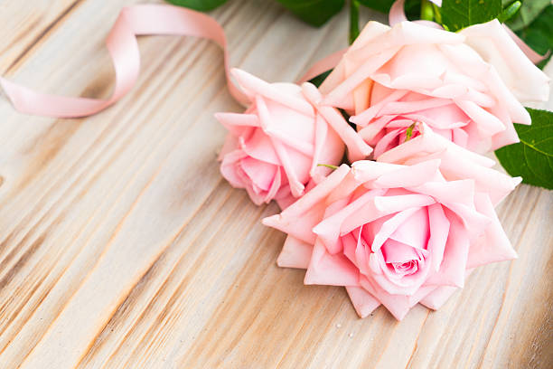 istock Pink blooming roses on wood 637995376