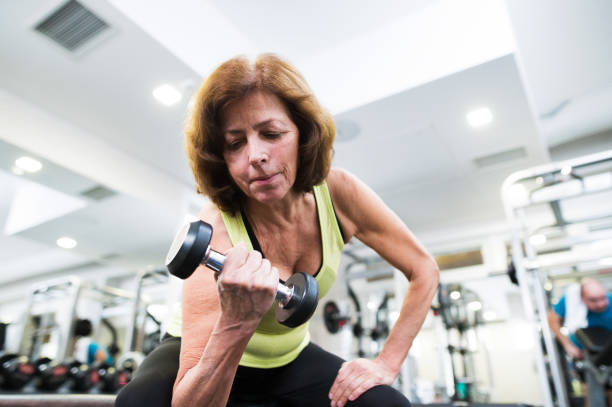 istock Senior woman in gym working out with weights. 637997584