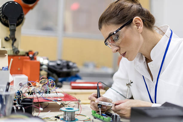 istock Electrician welding circuit board at desk 637999782