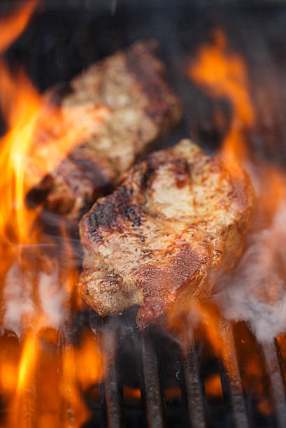 istock pork steak on bbq grill with flame 638001600