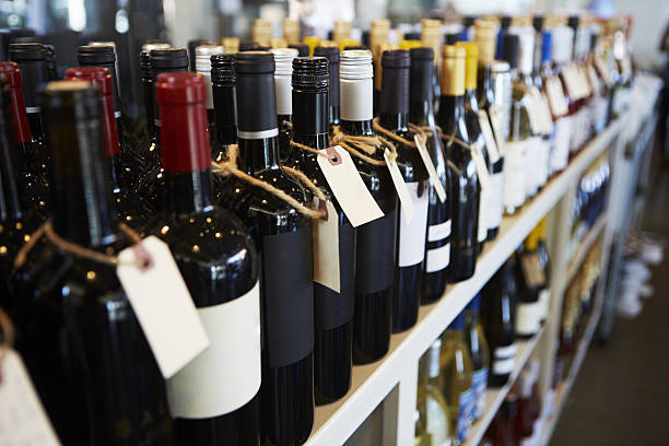 bottiglie di vino esposte in gastronomia - liquor store foto e immagini stock