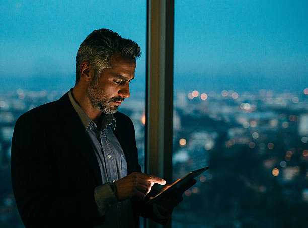 buisnessman mit tablet bei nacht - reflection businessman business telephone stock-fotos und bilder
