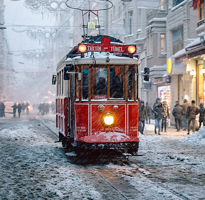 Nostalgic Trams passing through Istiklal street in a snowy winter day in Taksim, Beyoğlu, Istanbul, Turkey.